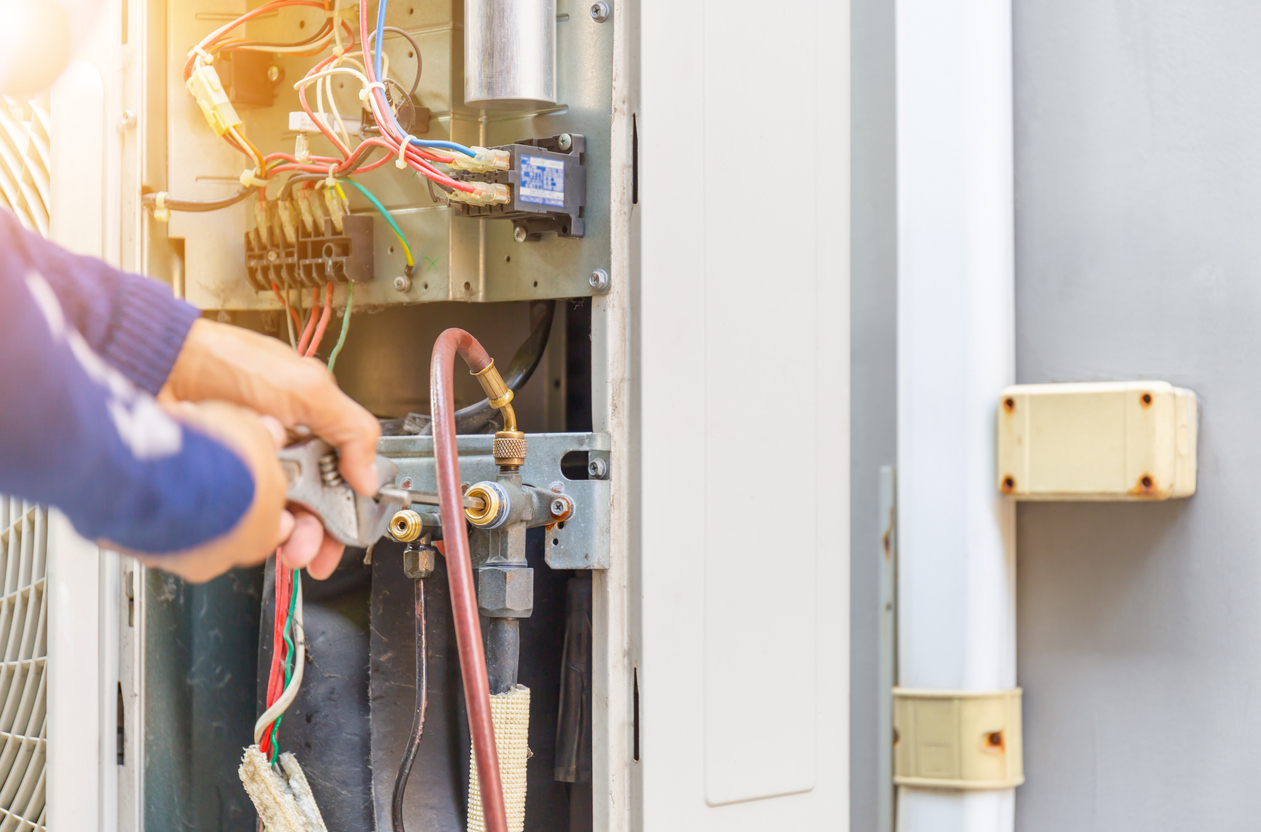 Selective focus of Air Conditioning Repair, repairman on the floor fixing air conditioning system